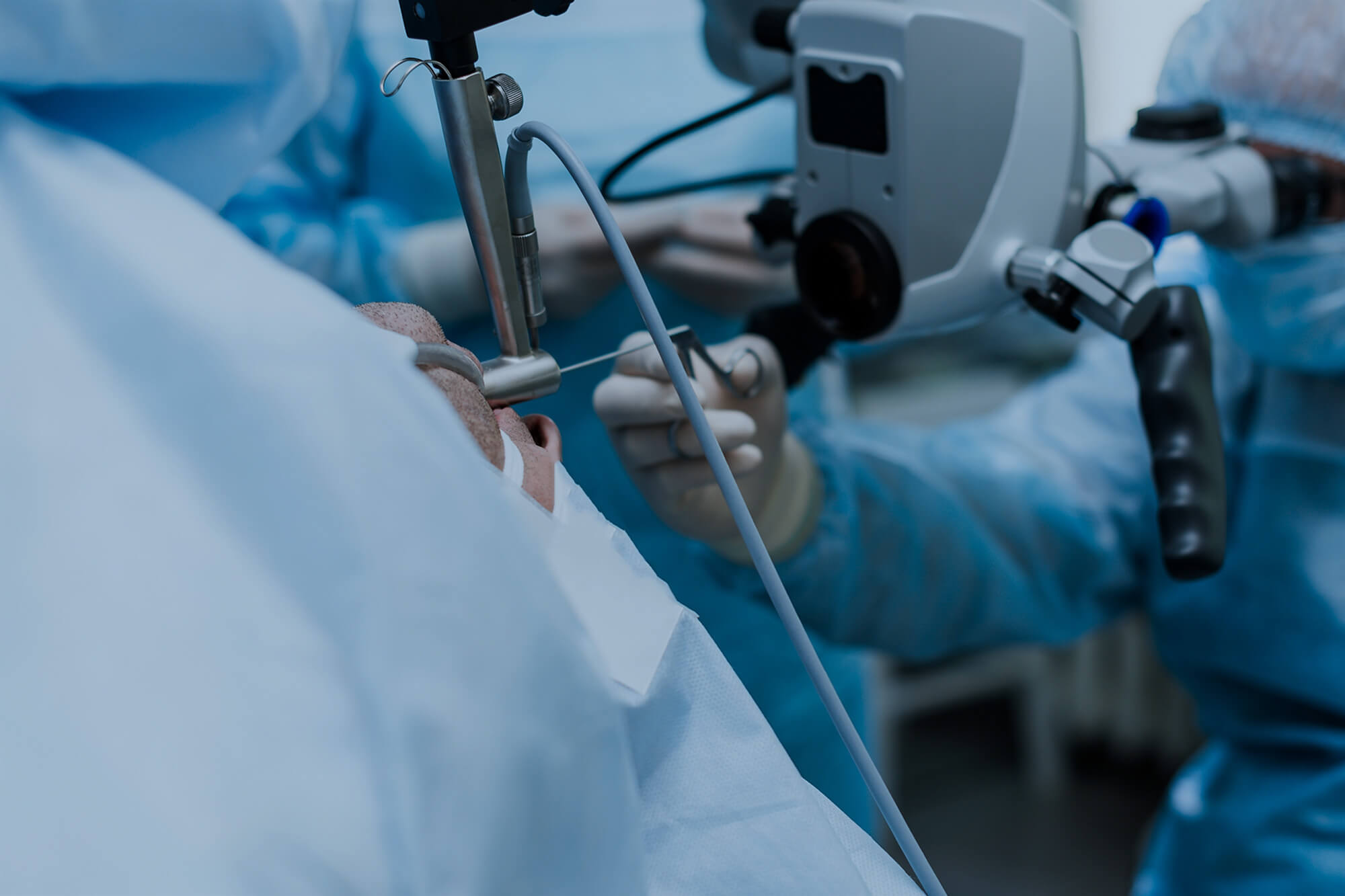 Surgeon operating a surgical microscope.