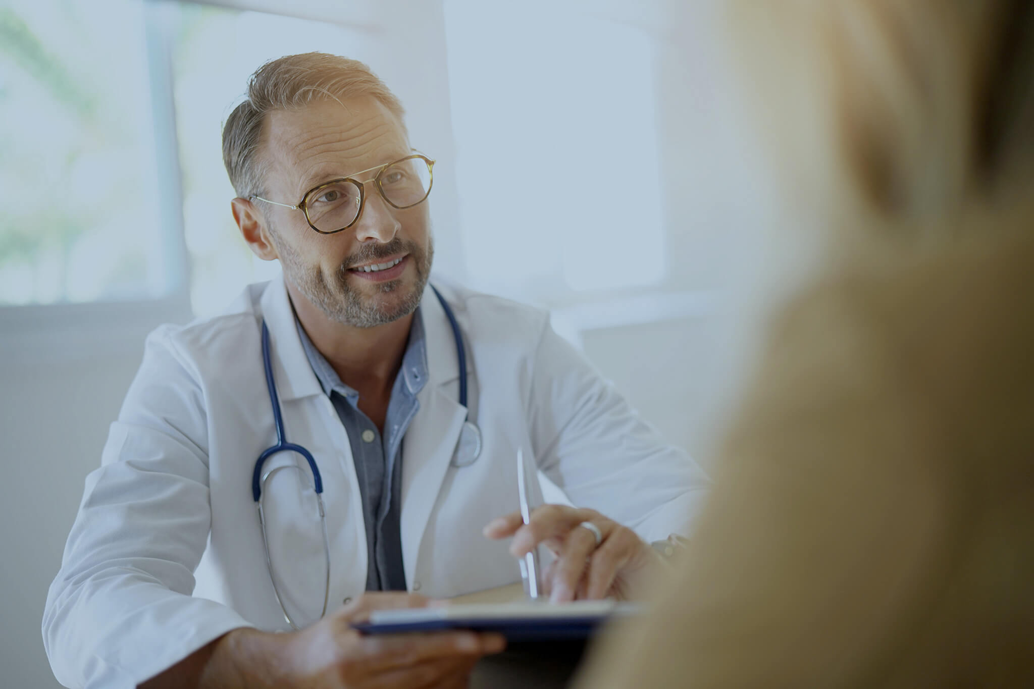 Male doctor talking with a patient in the office.