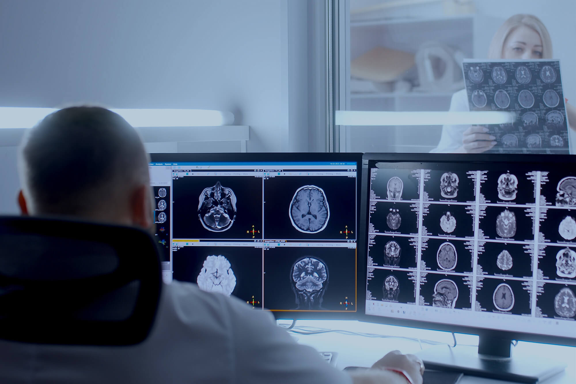 Neurologist analyzing patient's scan result in front of computer.