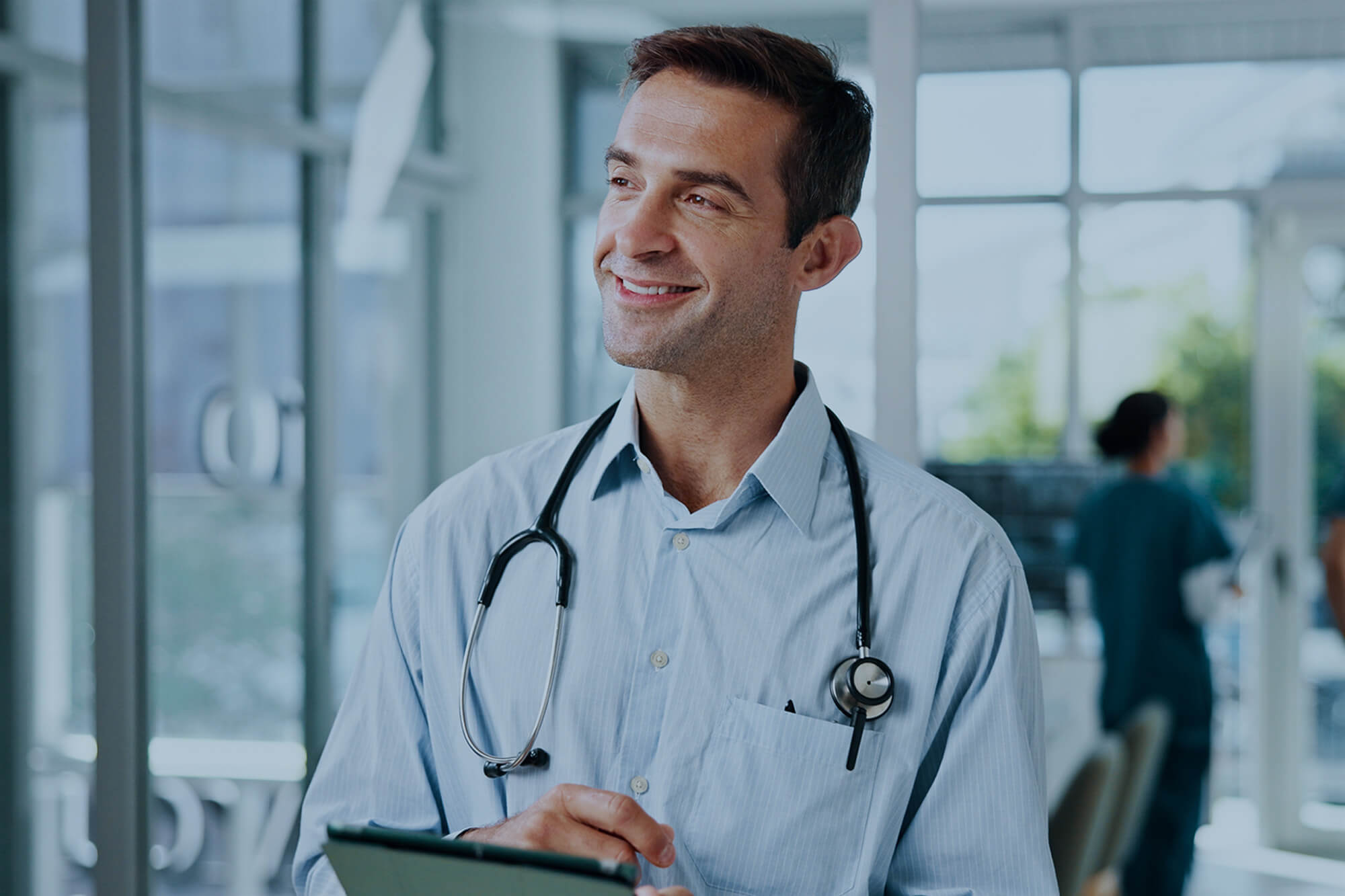 Happy doctor with tablet in the hospital.