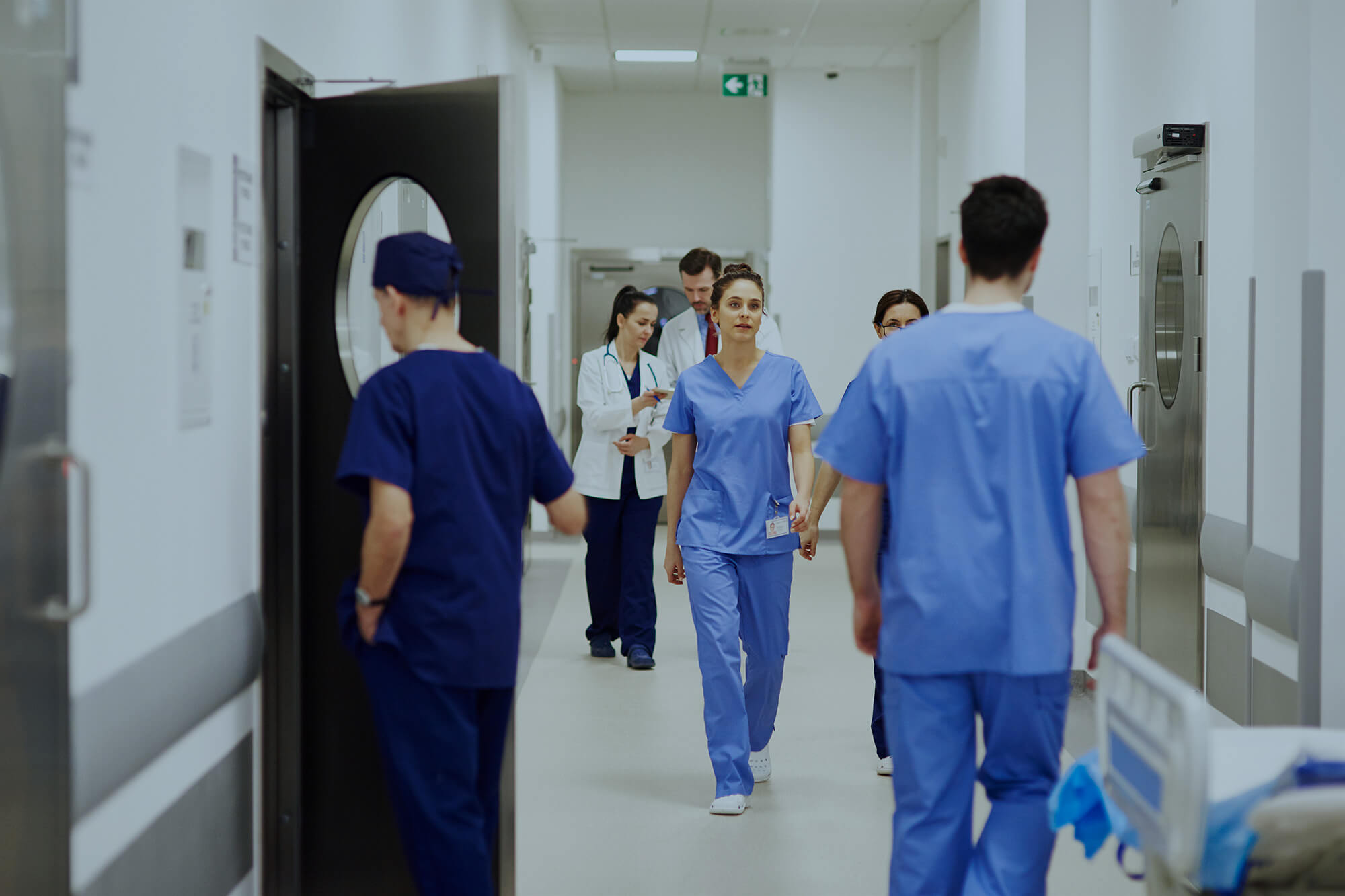 Doctors walking through corridor in hospital.