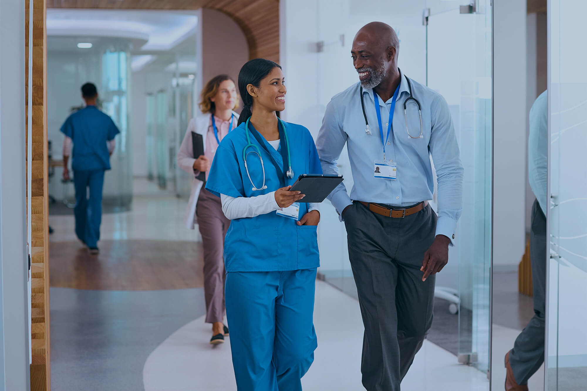 Businessman and doctor talking in hospital corridor.